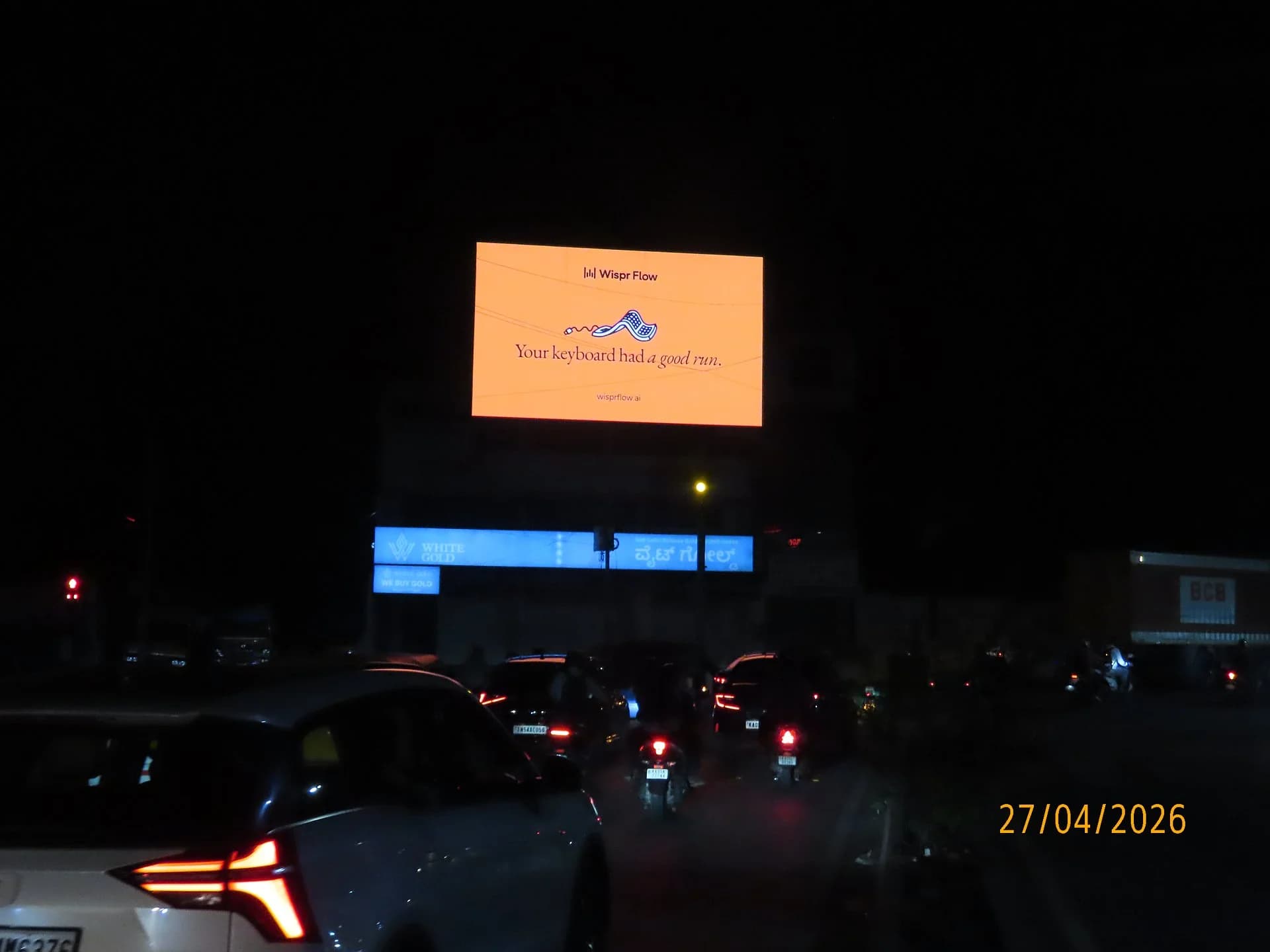 Illuminated billboard glowing orange above city traffic at night